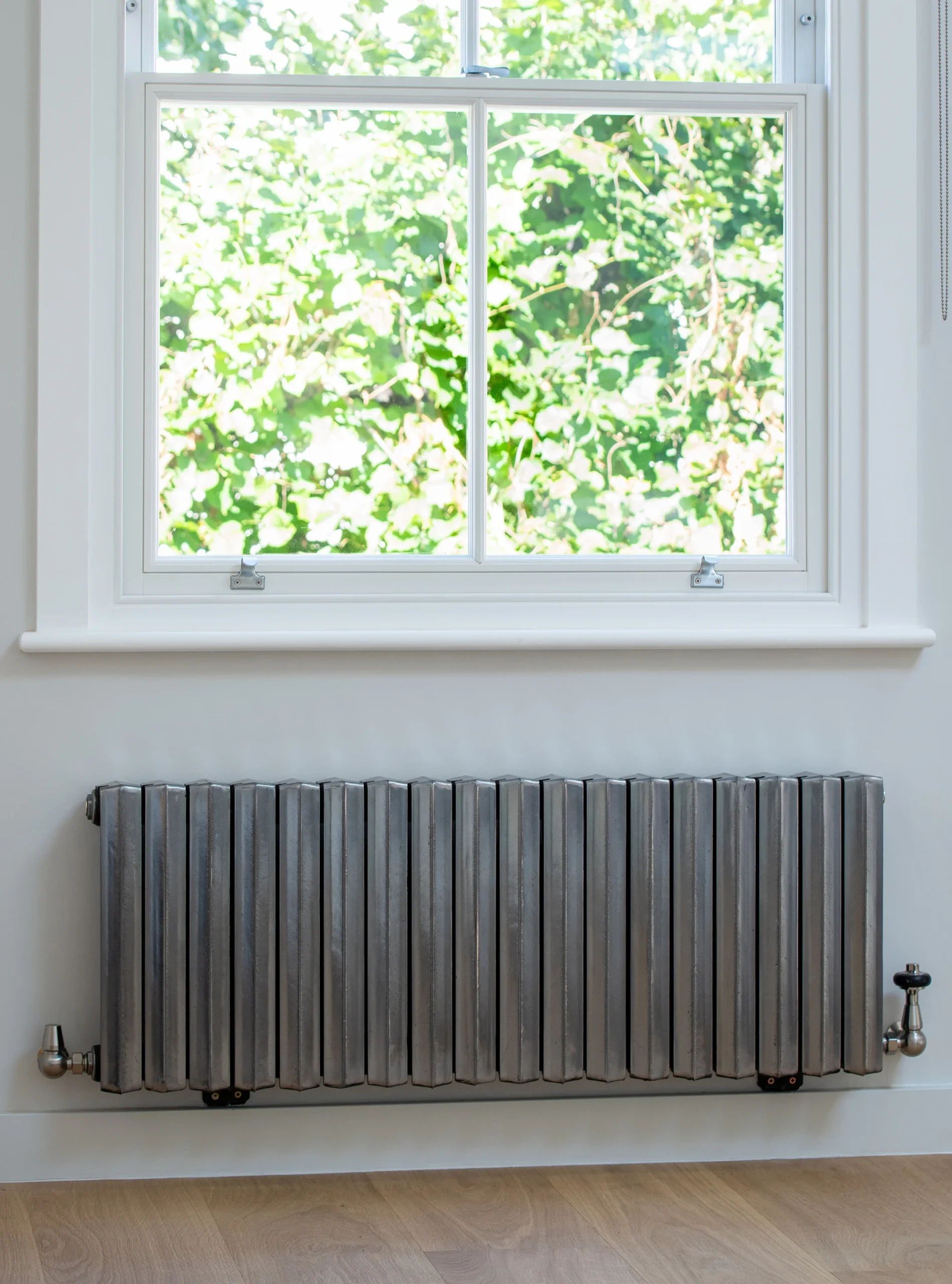 Restored sash window above a column radiator