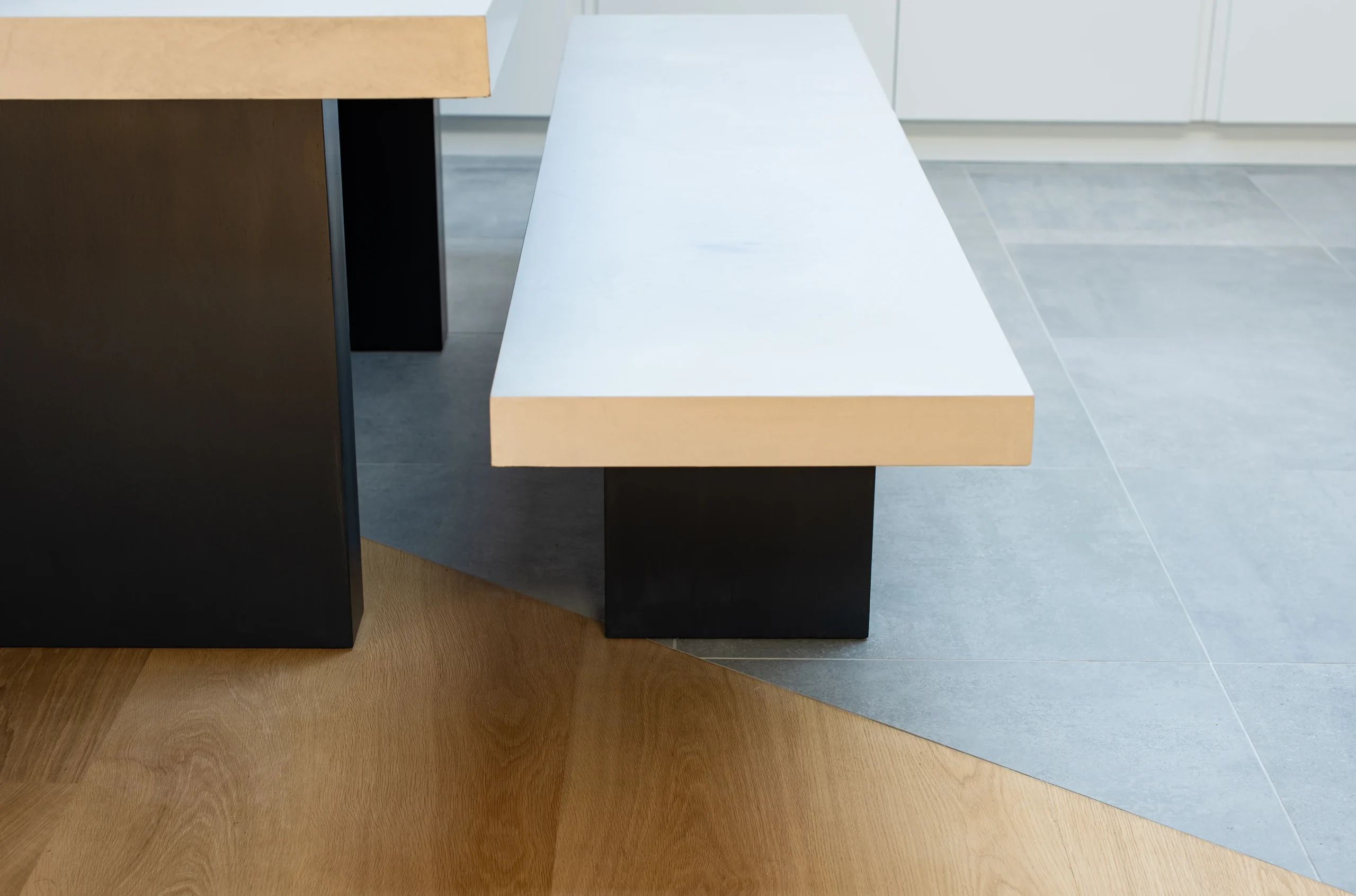 Oak bench and dining table on a pale stone floor where it meets the oak boards