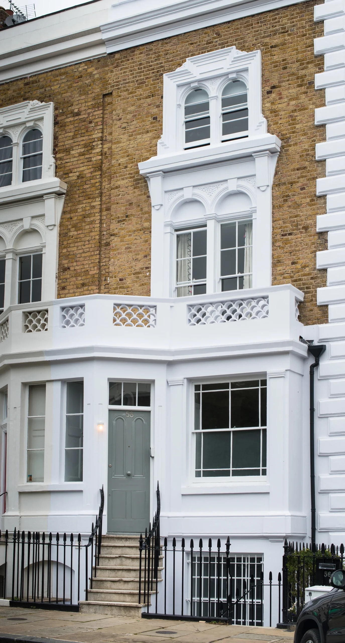 Camden_3_2160px Front elevation of a Camden Victorian terrace with white stucco, arched sash windows and balustraded balcony