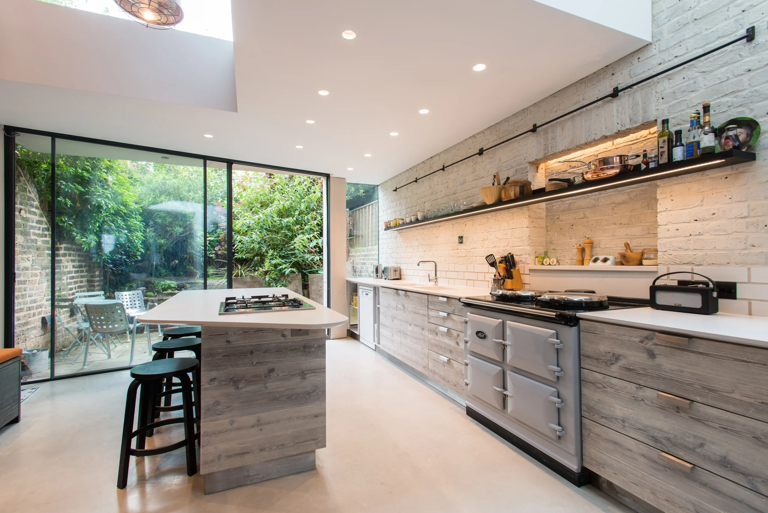 Camden_8_3840px Kitchen with reclaimed timber-fronted units, range cooker and black-framed sliding doors to the courtyard garden