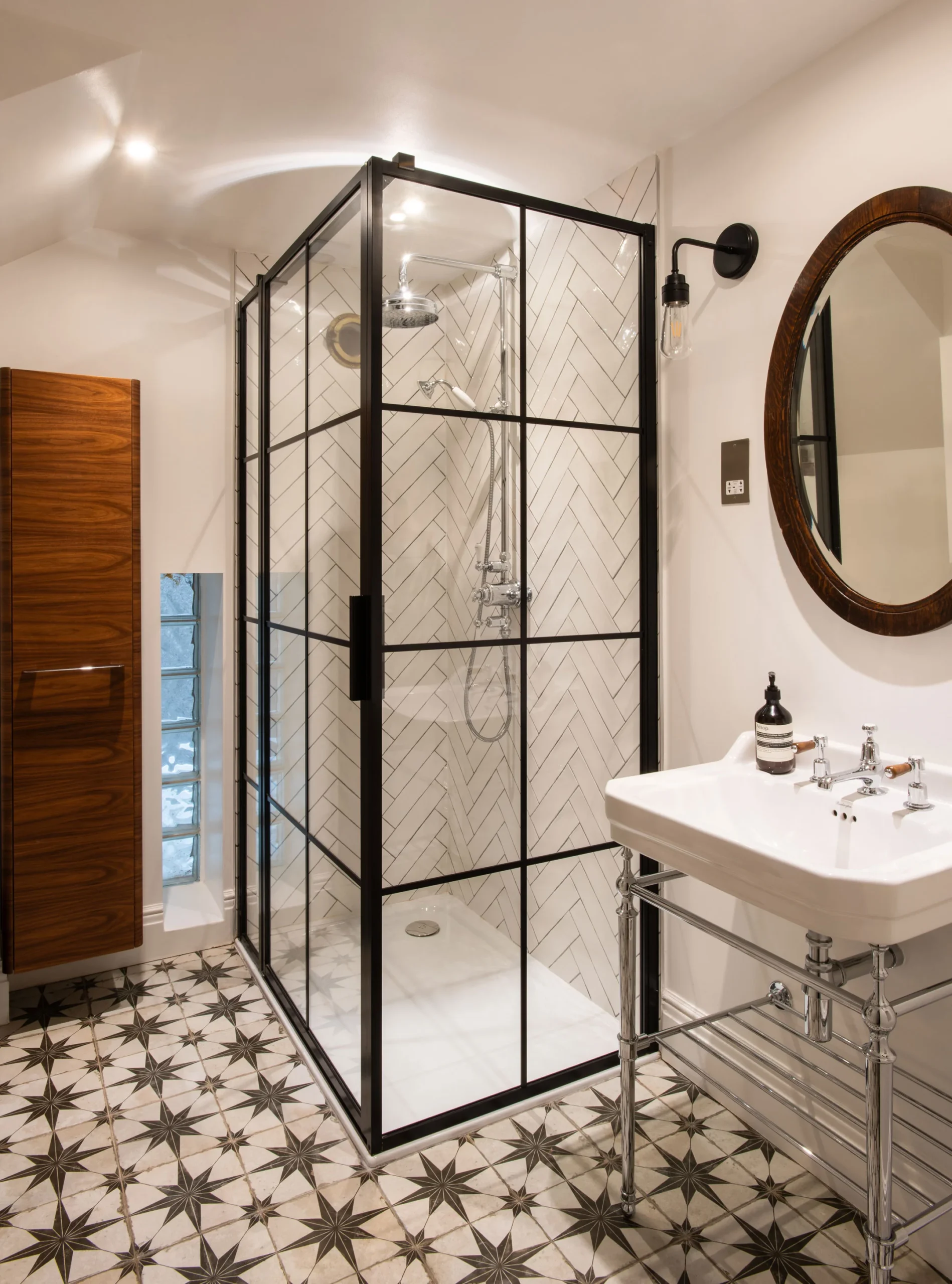 Shower room with crittall-style glass screen, pedestal basin and patterned floor tiles