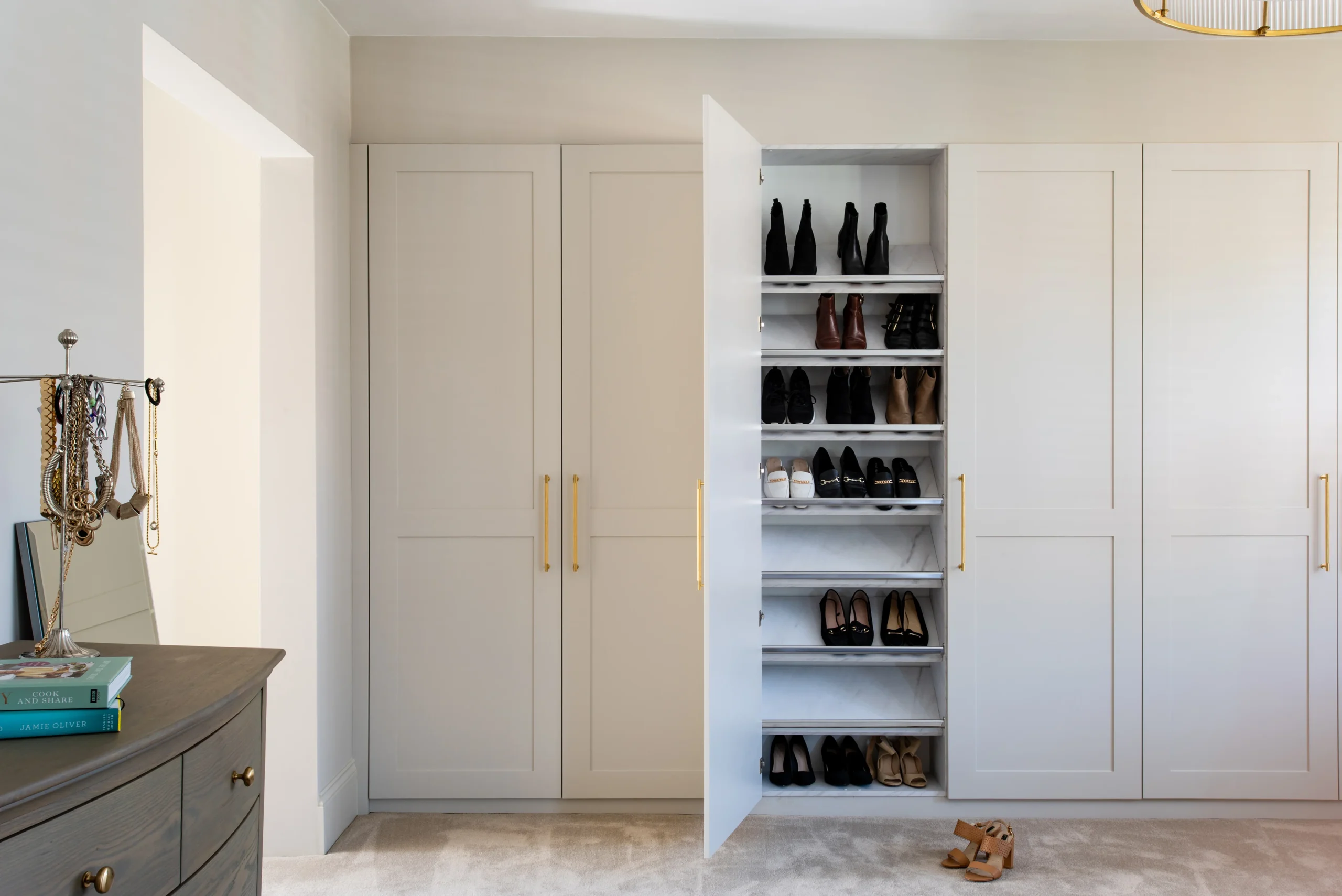 Fitted bedroom wardrobes with shaker doors, brass handles and open shoe shelving