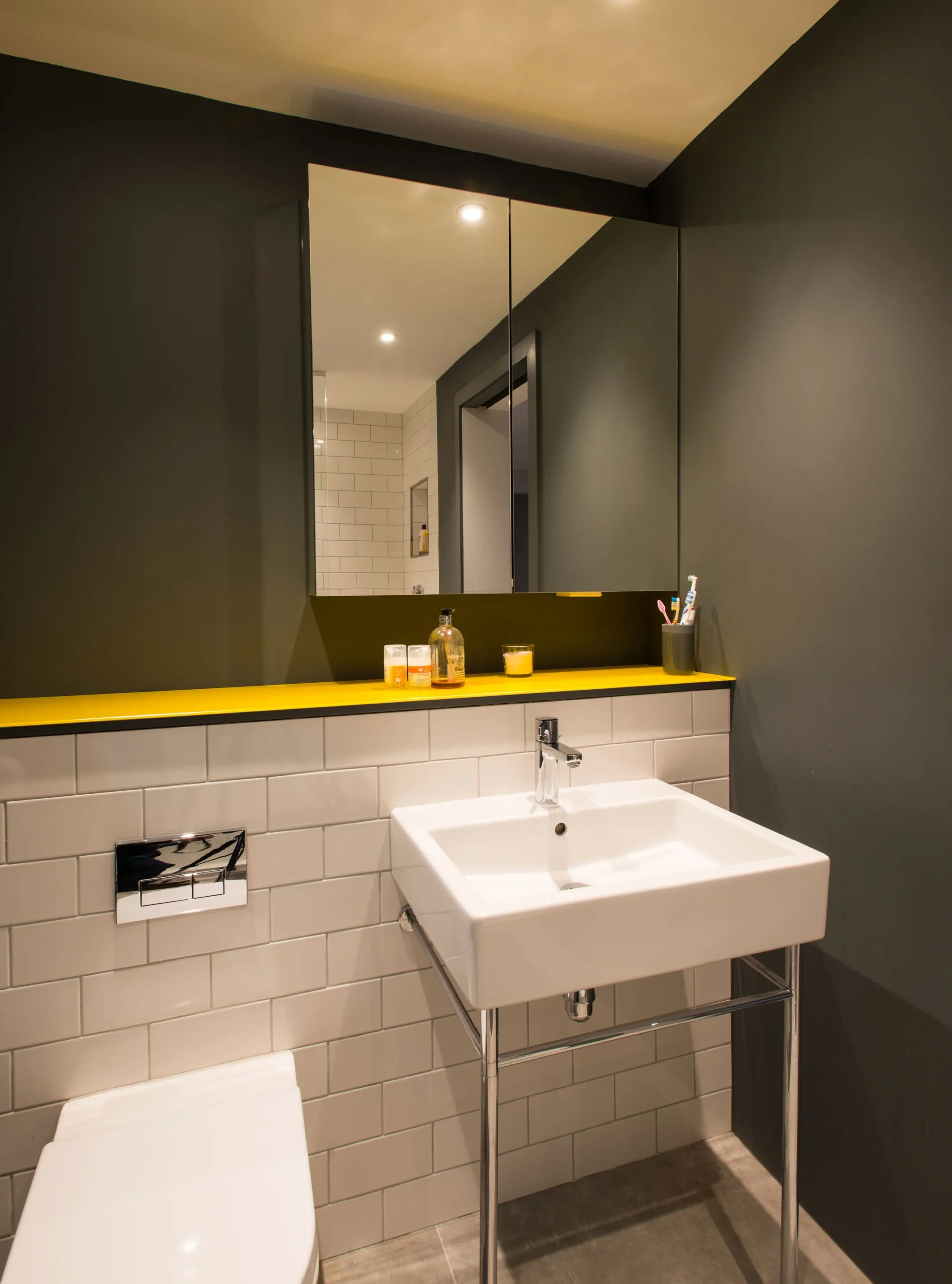 Cloakroom with wall-hung basin on a chrome stand, metro tiles and mirrored cabinet
