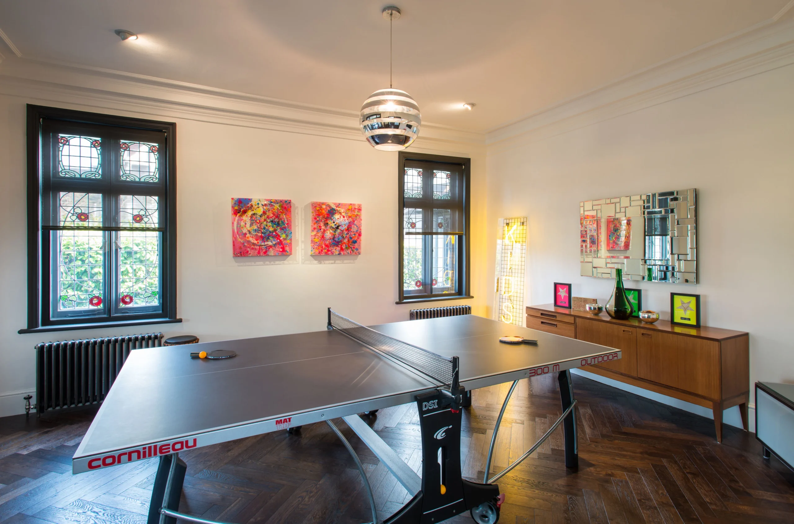 Games room in the original house with stained glass windows, herringbone parquet and table tennis table